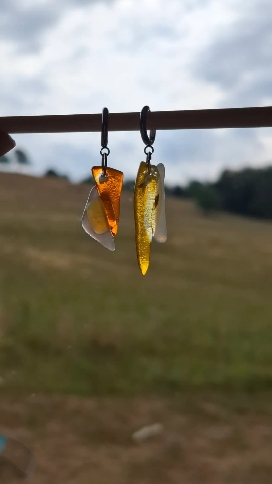 Boucles d'oreilles pendantes en verre translucide jaune et orange suspendues sur fond gris