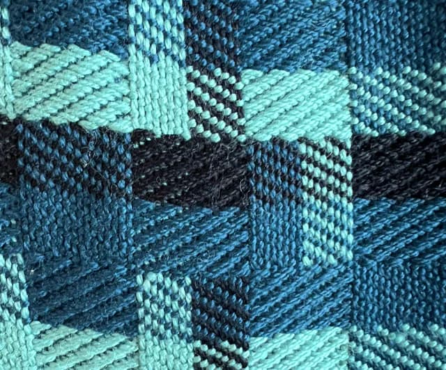 Détail du tissage texturé aux motifs géométriques bleu vif, canard et noir