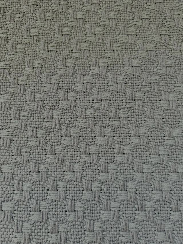 Gros plan sur les motifs géométriques et le tissage artisanal en coton.