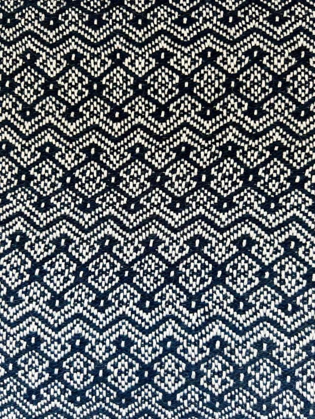 Détail du tissage artisanal aux motifs de losanges et chevrons bleu marine et blanc