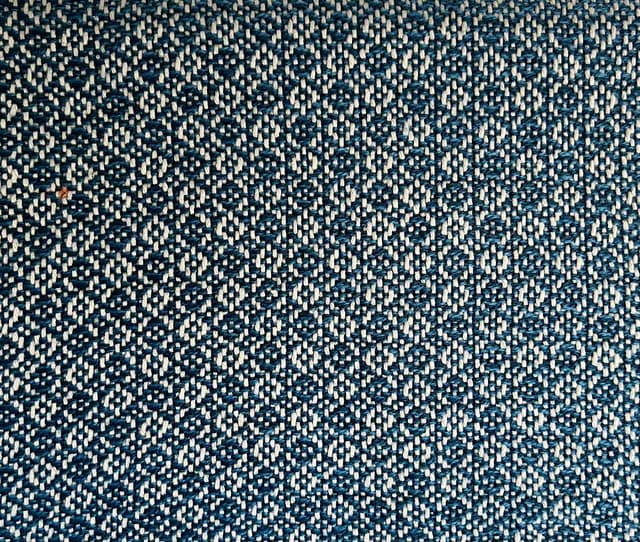 Gros plan sur le motif géométrique et la texture du tissage bleu et gris