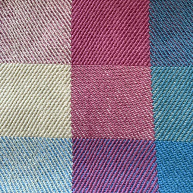 Détail de la texture du tissage sergé aux carreaux roses, bleus, jaunes et écru
