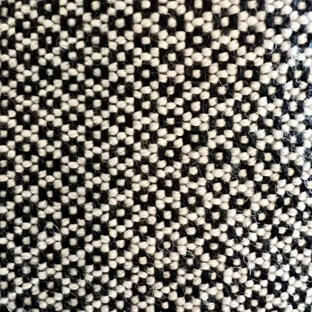 Gros plan sur le tissage noir et blanc aux motifs géométriques texturés.