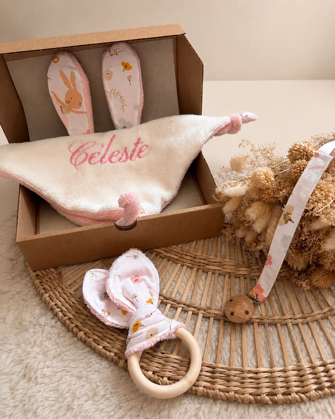 Doudou plat à oreilles de lapin, attache-tétine à fleurs et hochet anneau posés à plat