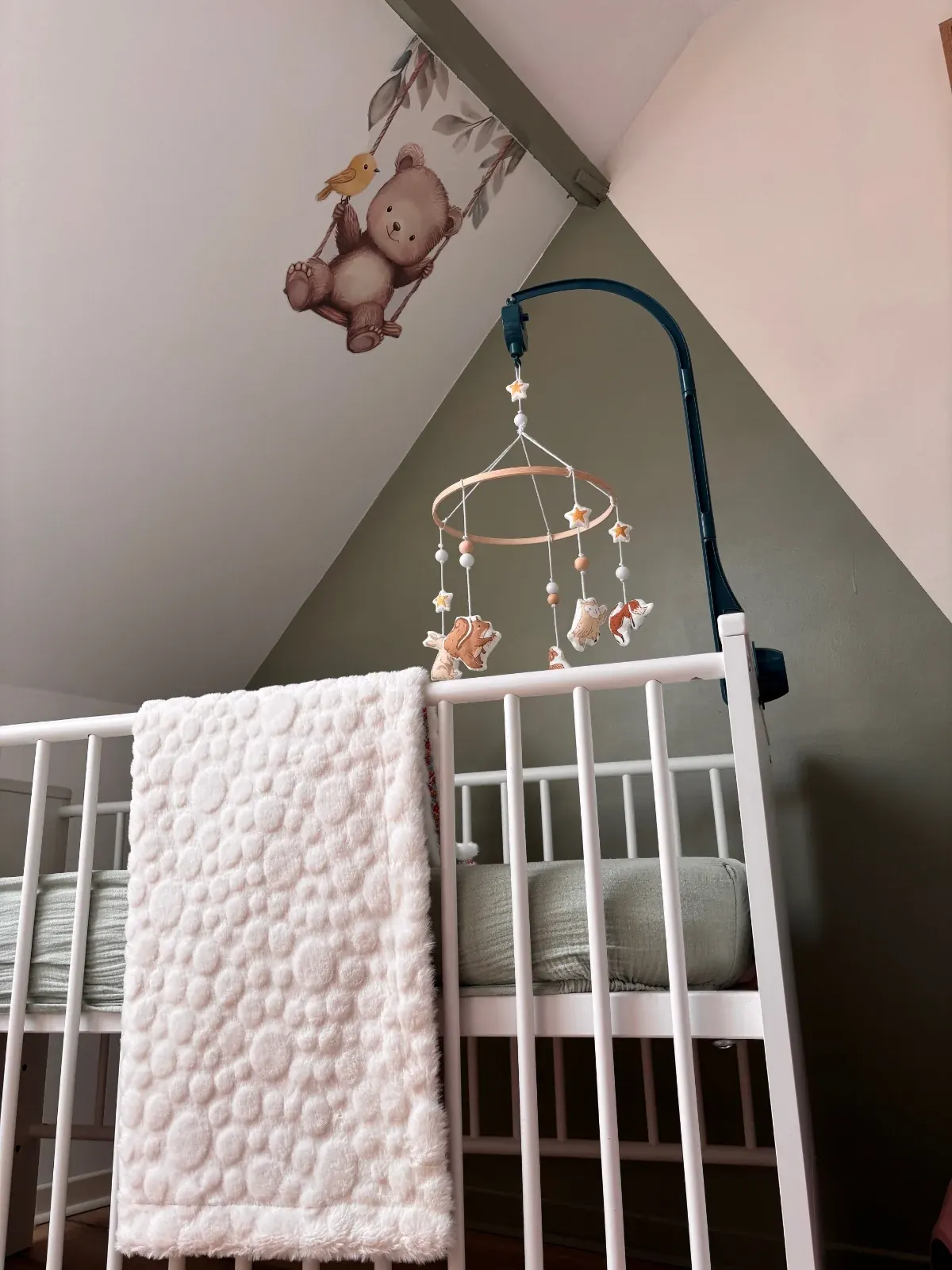 Couverture bébé double face à motif floral et polaire blanche dans un panier en osier en extérieur