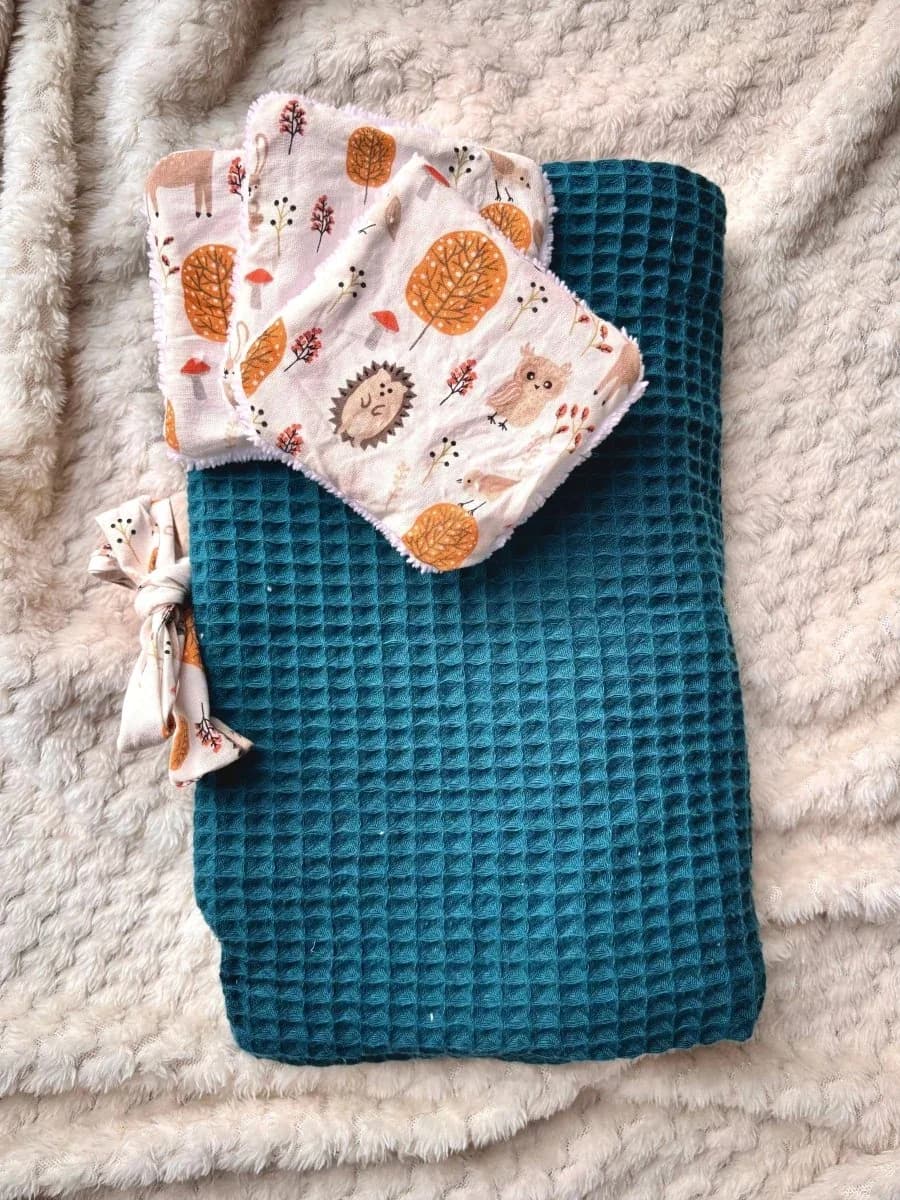 Tapis à langer plié en nid d'abeille bleu canard noué par un ruban avec deux lingettes assorties