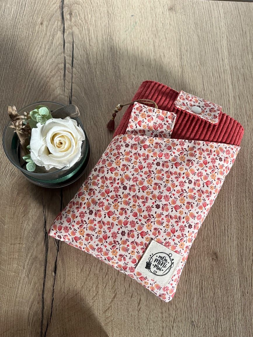 Pochette à livre en velours côtelé rose et tissu fleuri fermée avec son marque-page assorti.