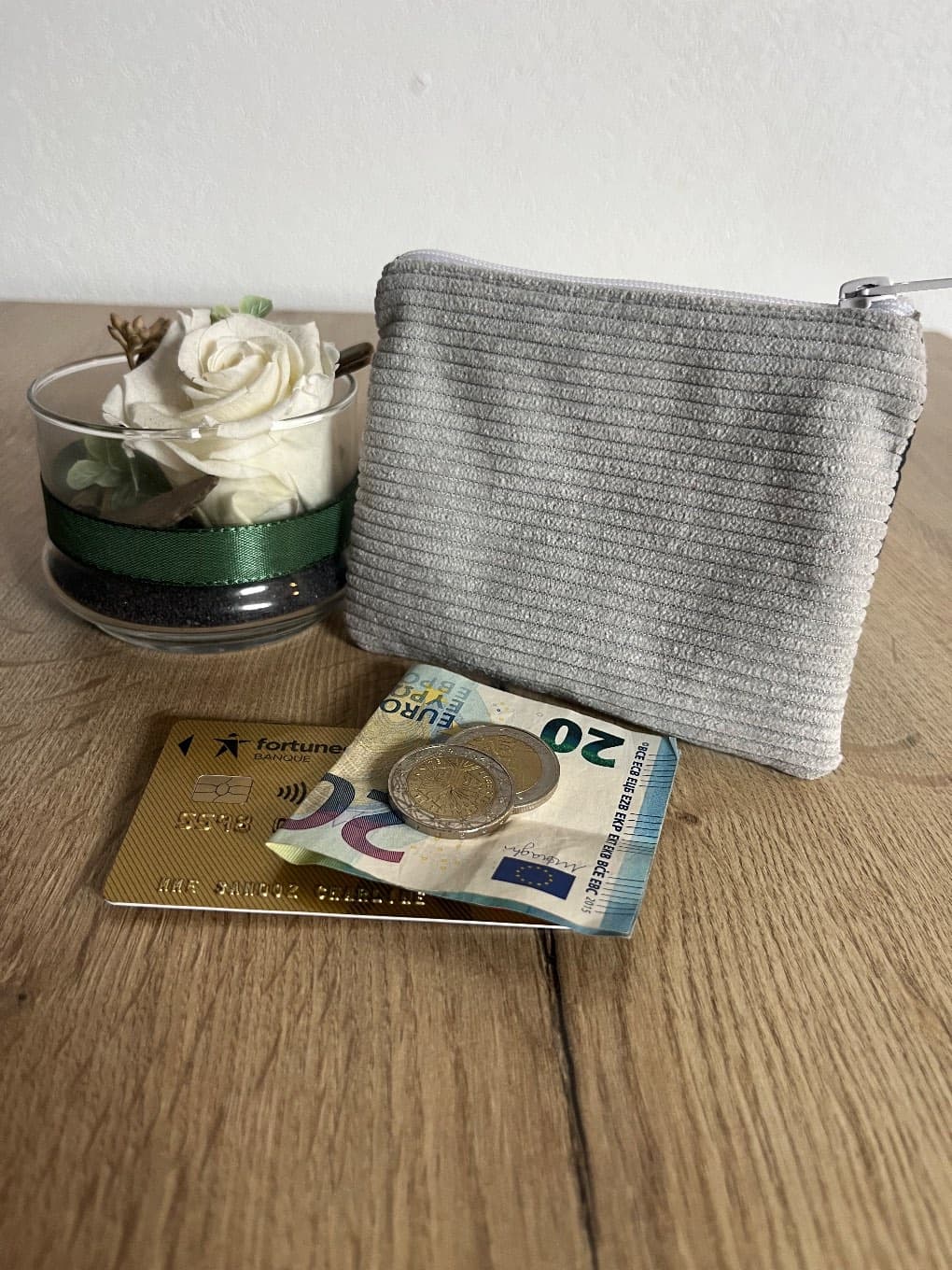 Face arrière en velours côtelé gris du petit porte-monnaie zippé fermé.