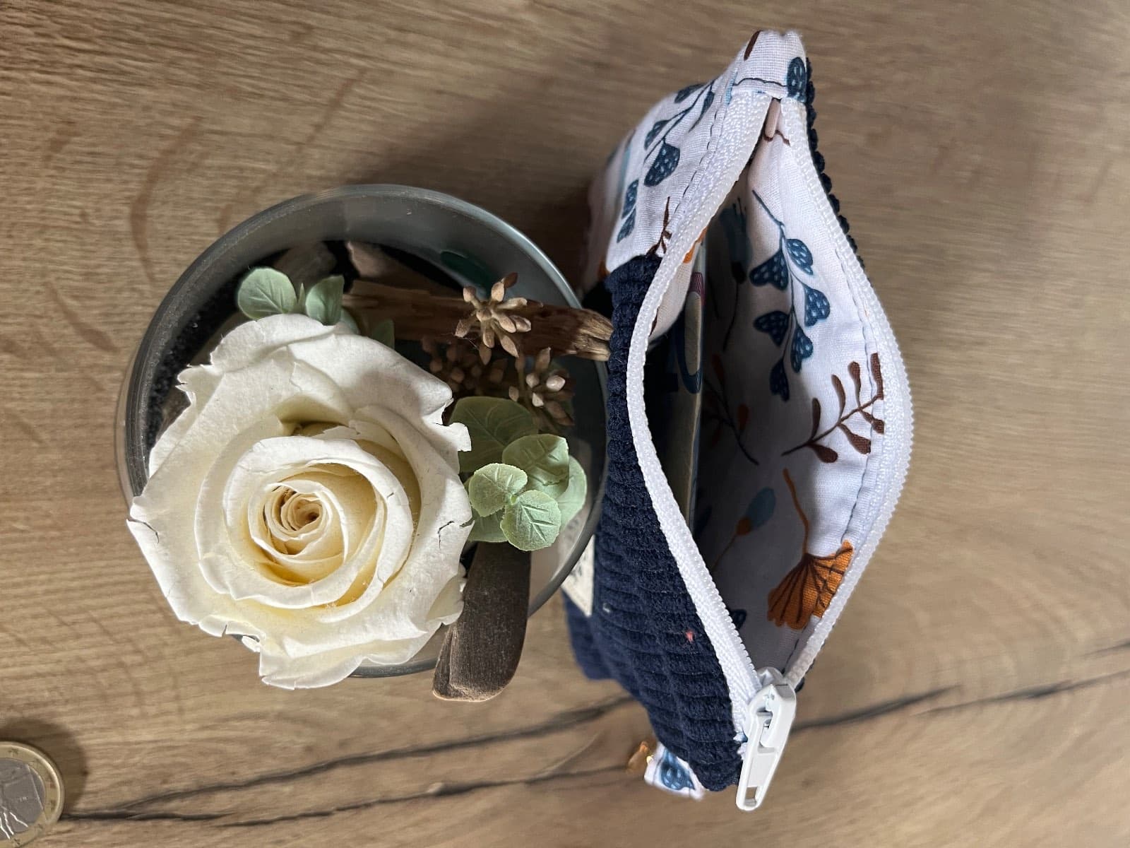 Vue du dessus de la pochette ouverte dévoilant la doublure en tissu clair à motifs de feuilles colorées