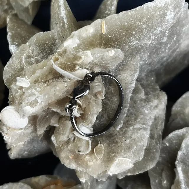 Vue de profil de l'anneau en argent avec motif cœur reposant sur une pierre minérale