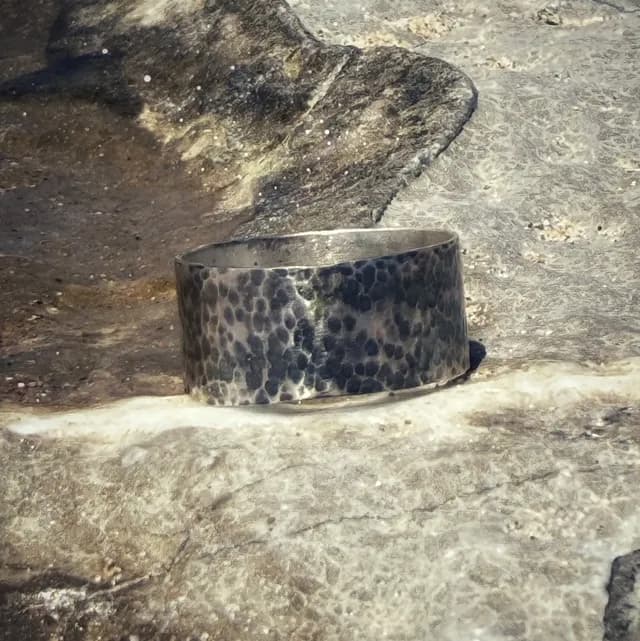 Bague bandeau en argent martelé à l'aspect brut sur fond minéral
