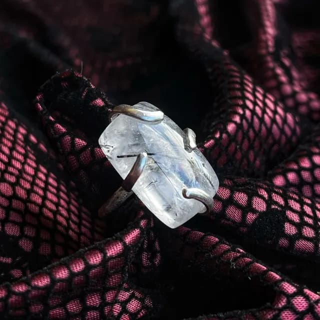 Bague réglable en argent avec quartz à inclusions de tourmaline portée au majeur.