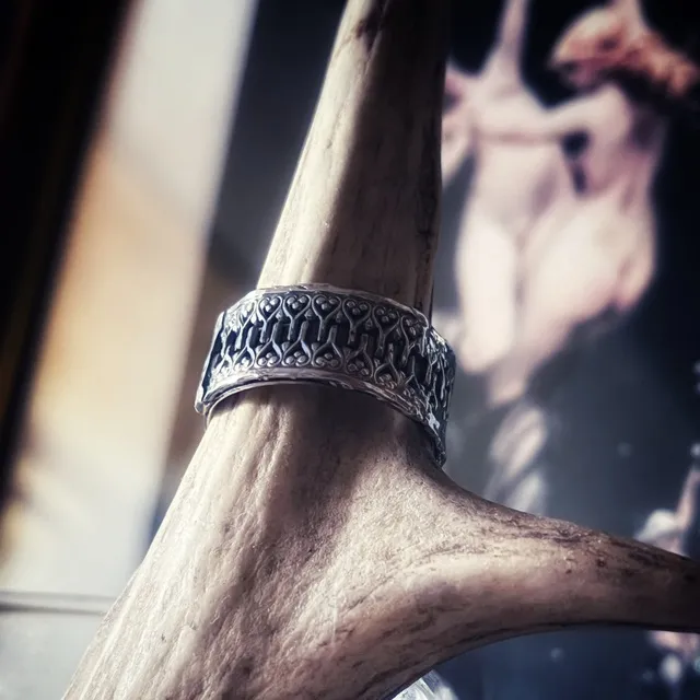 Vue de trois-quarts de l'anneau en argent gravé et sculpté de motifs gothiques.
