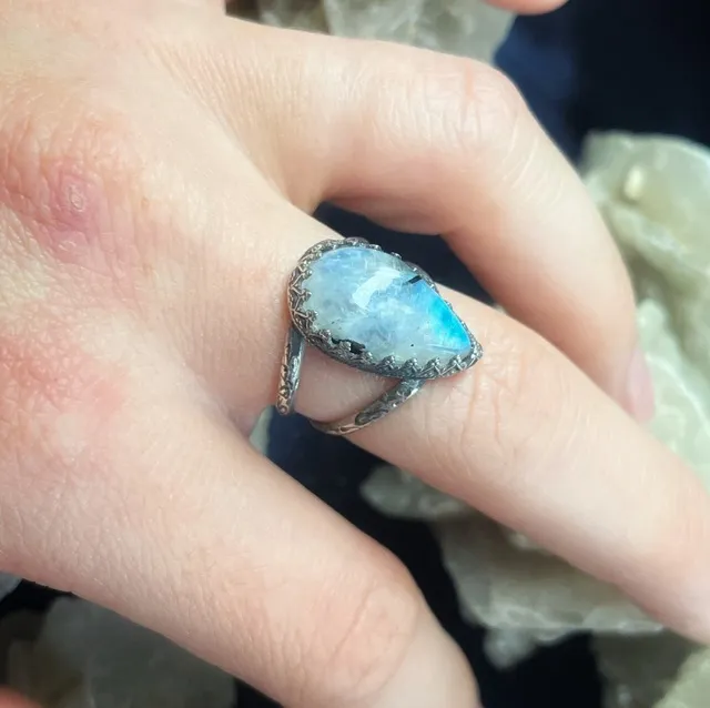 Vue du dessous de la bague en argent montrant l'anneau ajouré et texturé sur un minéral.