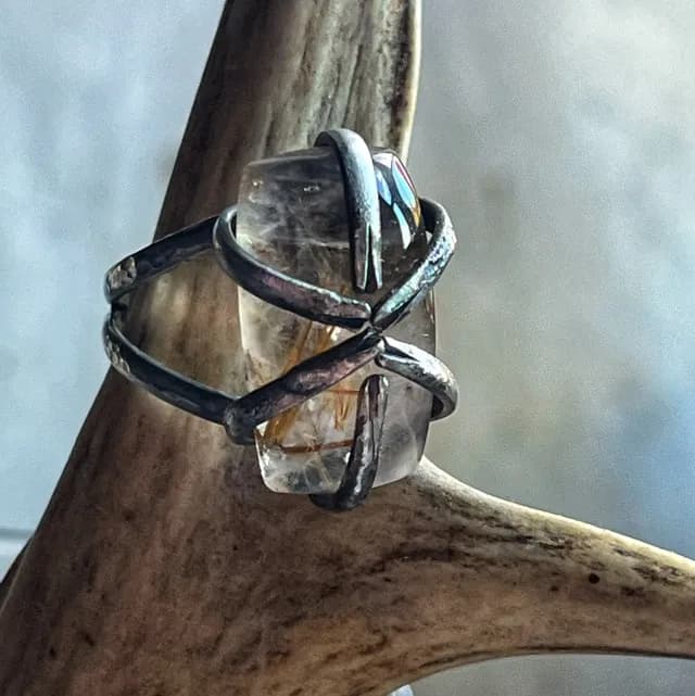 Gros plan sur la bague Sarcophage en argent texturé et pierre de quartz rutile transparent