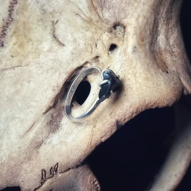 Bague en argent ornée d'une obsidienne brute noire posée dans un creux osseux