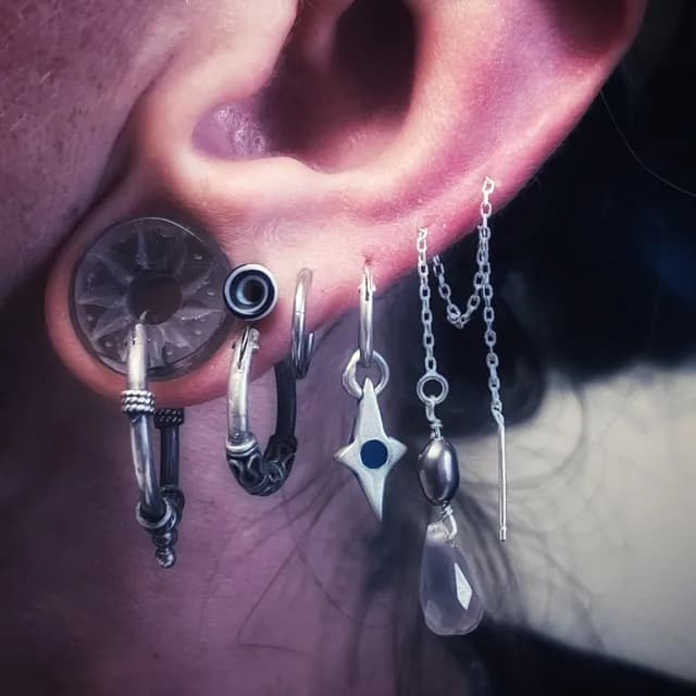 Chaînette d'oreille en argent portée à travers plusieurs trous de piercing