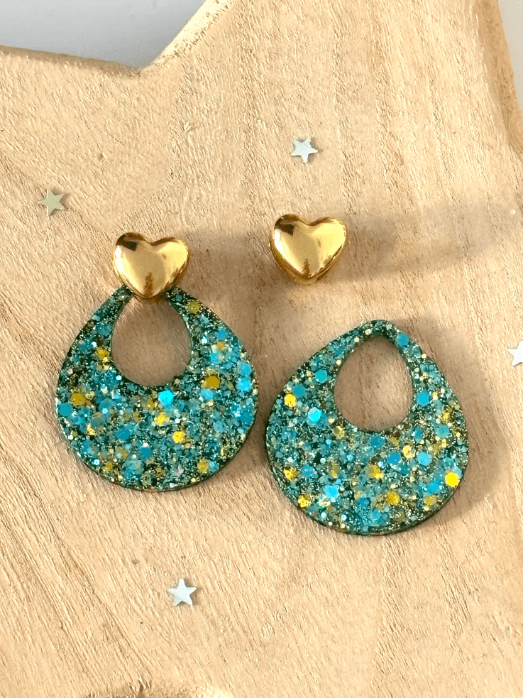 Clous cœurs dorés lisses et pampilles ajourées turquoise à paillettes sur fond blanc