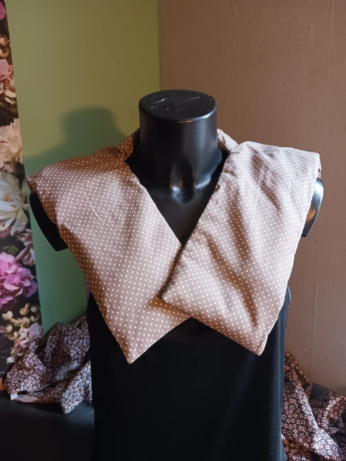 Bouillotte d'épaules beige taupe à pois blancs portée sur un mannequin, vue de face.