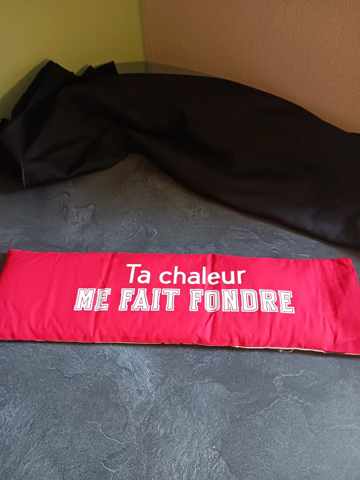 Bouillotte allongée en tissu rouge avec l'inscription blanche Ta chaleur me fait fondre