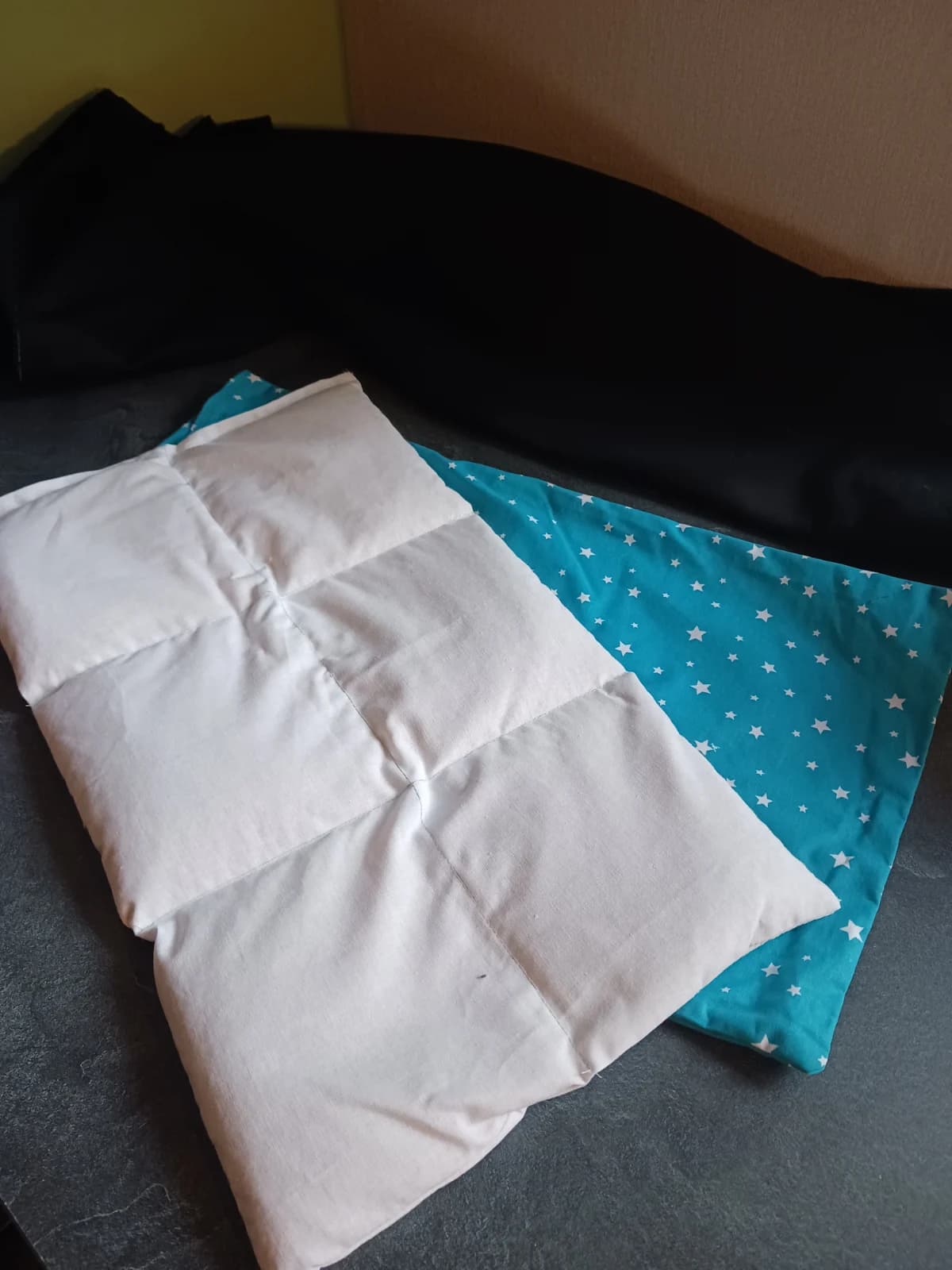 Coussin intérieur blanc à 6 compartiments présenté avec sa housse turquoise à étoiles.