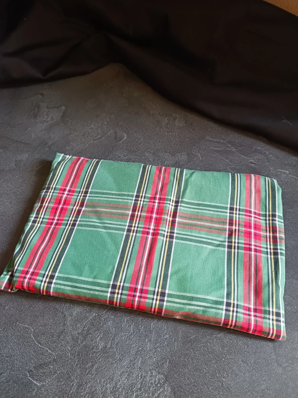 Coussin bouillotte rectangulaire en tissu tartan vert à carreaux rouges et jaunes.