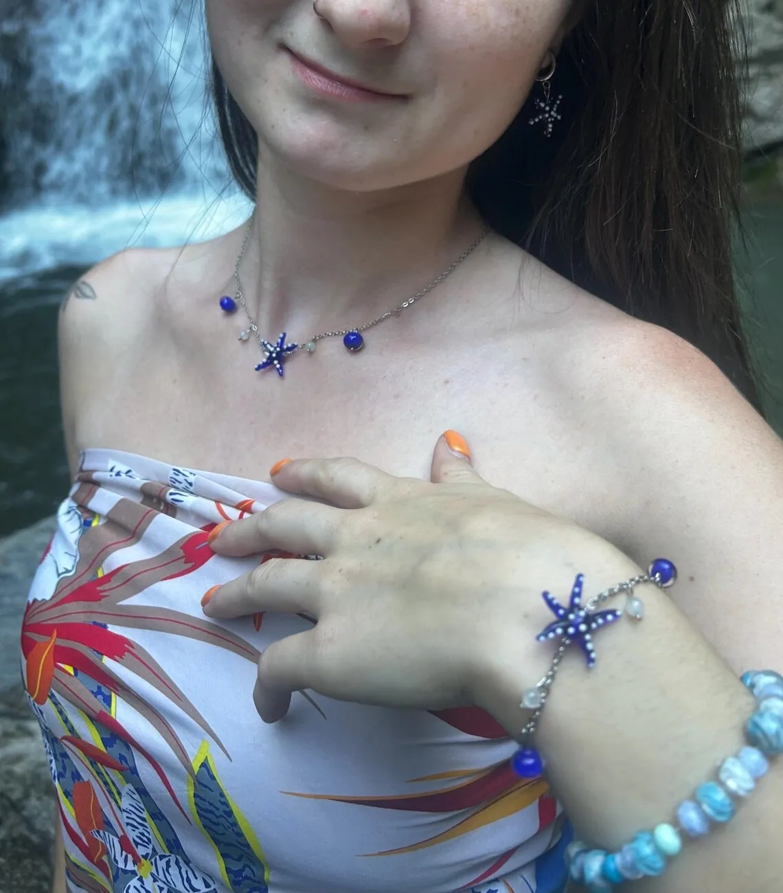 Bracelet fin à chaîne avec motif étoile de mer bleue à pois blancs et perles au poignet