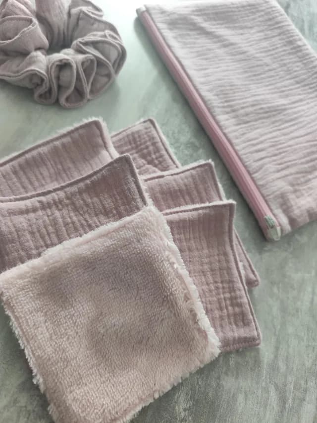Vue à plat du kit rose composé d'une pochette zippée, d'un chouchou et de lingettes lavables.