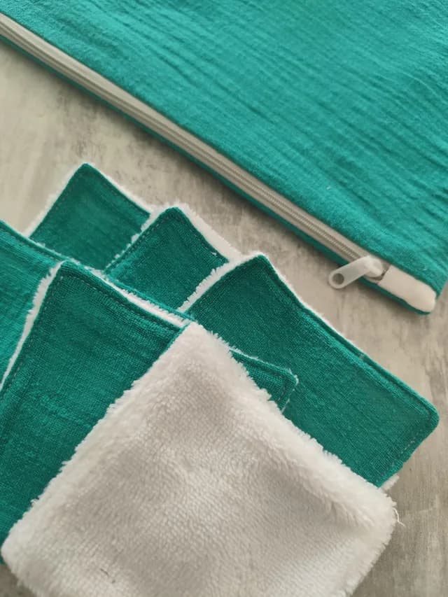 Gros plan sur les lingettes lavables turquoise et blanches avec la pochette zippée