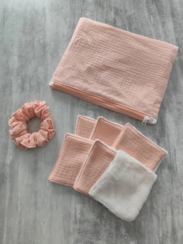 Kit rose composé d'une pochette zippée, d'un chouchou assorti et de lingettes lavables carrées.