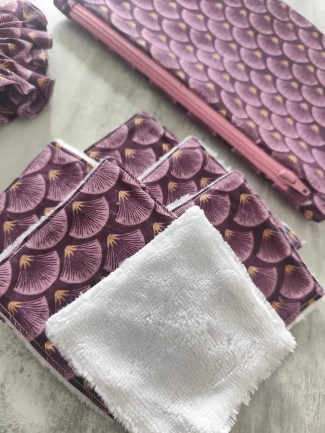 Gros plan sur les lingettes lavables en tissu violet et blanc avec la pochette assortie.
