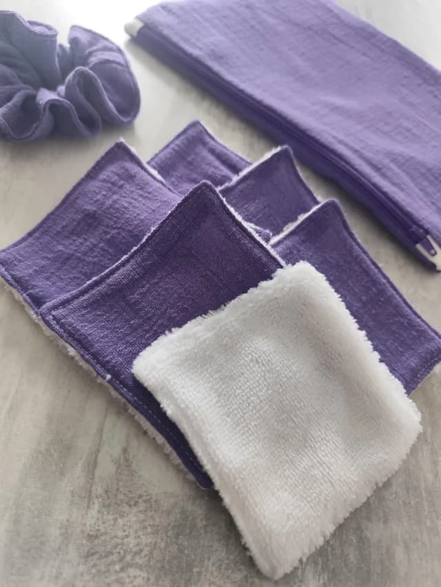 Détail des lingettes lavables violettes et blanches avec pochette zippée et chouchou en fond
