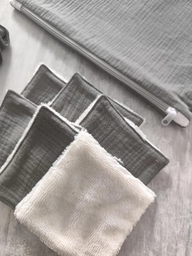 Gros plan sur les lingettes lavables carrées grises et blanches à côté de la pochette zippée