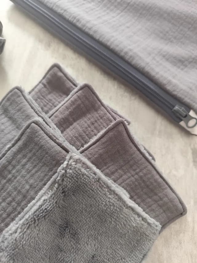 Détail rapproché des lingettes lavables grises montrant le tissu texturé et le côté tout doux.