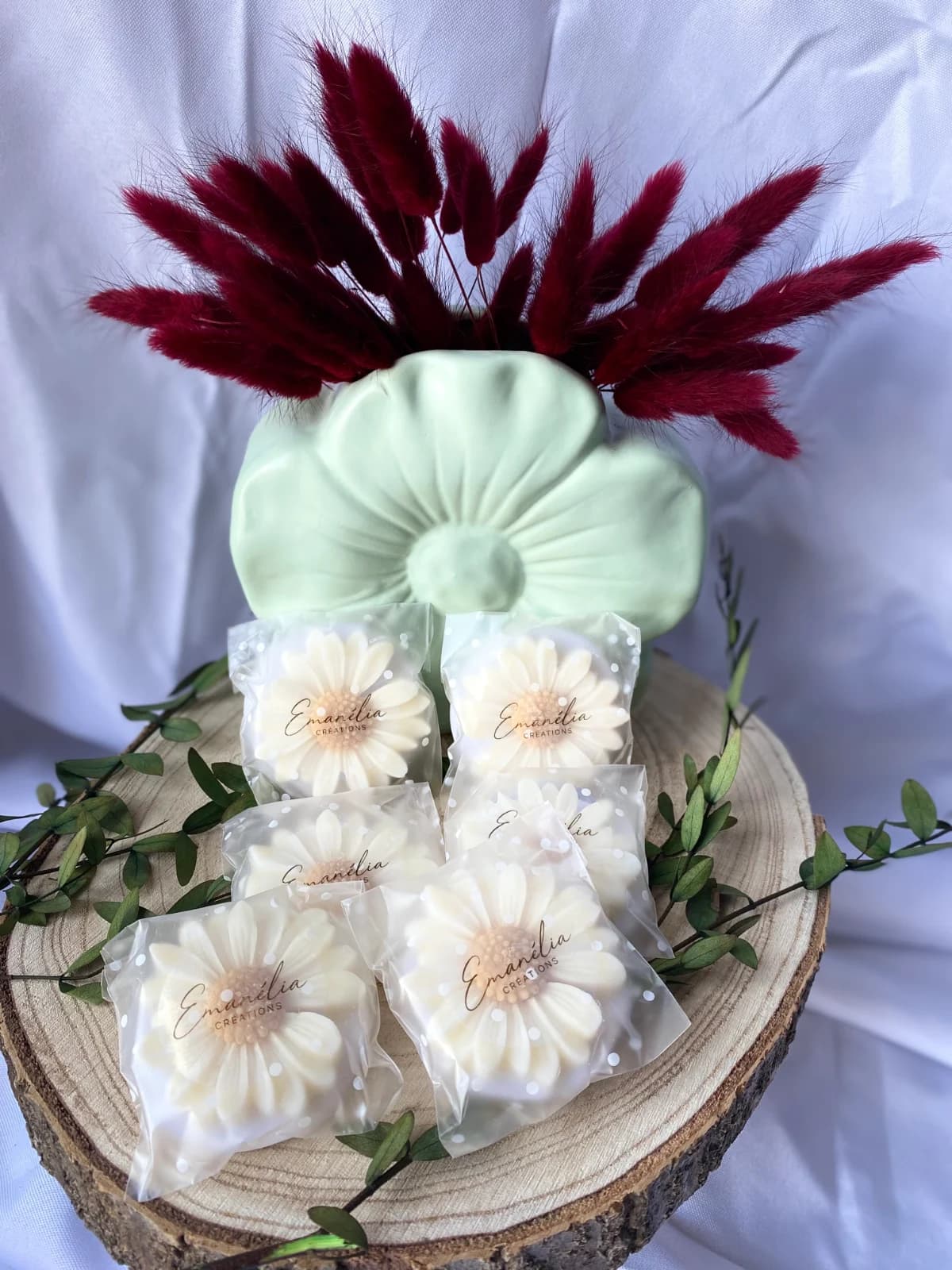 Fondants parfumés marguerite emballés individuellement posés sur un rondin de bois.